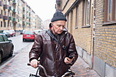 Älterer Mann mit Handy in der Hand
