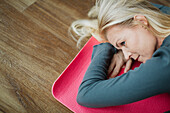 Woman relaxing on exercising mat