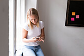 Young woman in office using cell phone