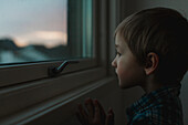 Junge schaut durch ein Fenster