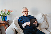 Älterer Mann mit digitalem Tablet