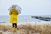 Mädchen mit Regenschirm am Meer