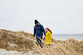 Vater und Tochter gehen am Strand spazieren