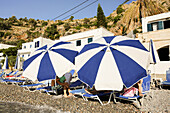 Sonnenschirme mit Liegestühlen am Strand