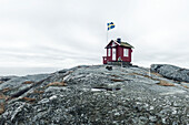 Haus auf einem Felsen mit schwedischer Flagge