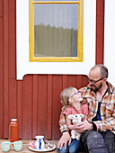 Vater mit Tochter vor einem Haus
