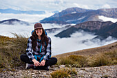 Lächelnde junge Frau mit Bergen im Hintergrund