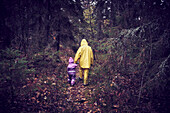 Parent with child walking through forest