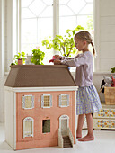 Mädchen spielt mit Puppenhaus