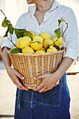 Woman holding basket full of lemons