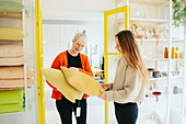 Woman in shop showing cushions to customer