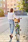 Frau zu Fuß mit Fahrrad