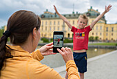 Mother taking photo of her son