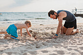 Father playing with son on beach
