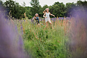 Girls running through meadow