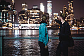 Couple looking at illuminated skyscrapers