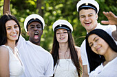 Happy friends wearing graduation caps