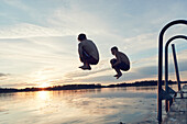 Boys jumping into lake