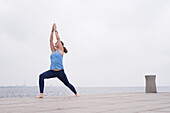 Woman doing yoga at sea