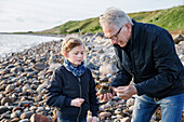 Grandfather with granddaughter on beach