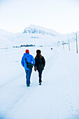 Couple walking on snow-covered road