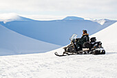 Man on snowmobile in winter landscape