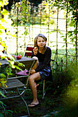 Blond girl eating apple in orchard