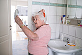 Ältere Frau beim Kämmen der Haare