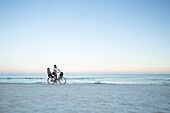 Couple cycling on beach