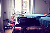 Little girl playing piano in living room