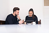 Couple in cafe using digital devices