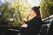 Schwangere Frau auf einer Bank sitzend