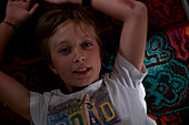 Portrait of smiling boy lying on carpet