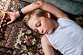 Boy lying on carpet