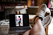 Legs of man using laptop at home