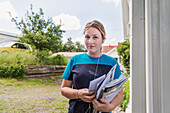 Portrait of young female mail carrier