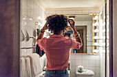 Frau bereitet Haare im Badezimmer vor