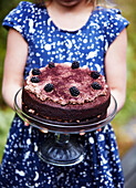 Mädchen mit Schokoladenkuchen in der Hand