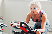 Woman exercising on stationary bicycle in gym