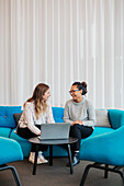 Two friends sitting in living room with laptop