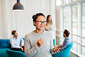 Young woman listening music while other friends sitting in background