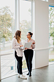 Two women talking in corridor