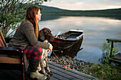 Frau mit Hund nachdenklich am Meer