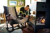 Man putting firewood into fireplace