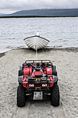 Four-wheeler and boat on beach