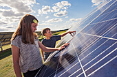 Boy and girl standing next to solar panels