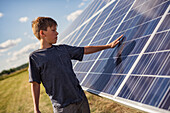 Junge berührt Solarzellen