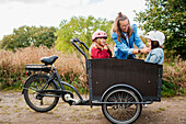 Mother and daughters near bicycle cart