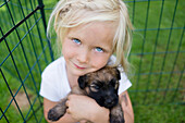 Portrait of girl holding puppy