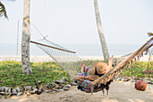 Frau liegt in Hängematte am Strand